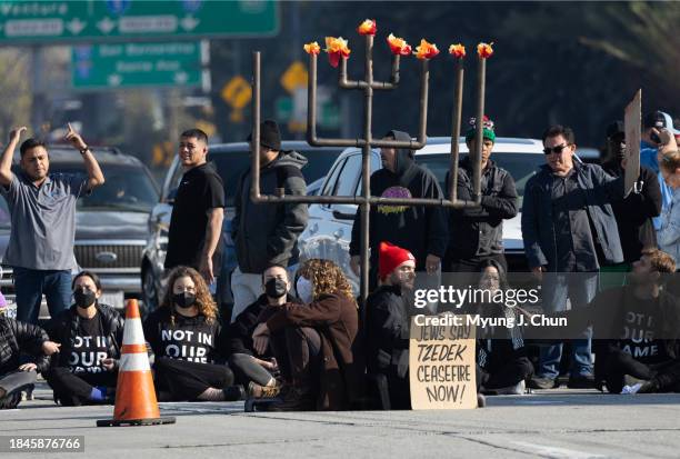 Demonstrators block the 110 freeway in downtown on Wednesday, Dec. 13, 2023 in Los Angeles, CA to call for a ceasefire in the Israeli-Hamas conflict.