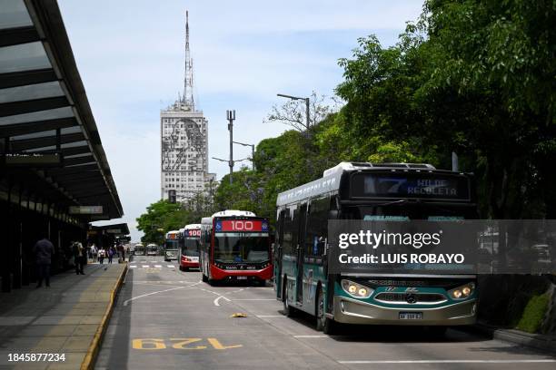 Buses pass on 9 de Julio Avenue in Buenos Aires on December 13, 2023. Argentina devalued its currency by more than 50 percent Tuesday in a set of...