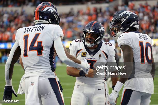 Russell Wilson of the Denver Broncos celebrates a touchdown pass with Courtland Sutton of the Denver Broncos during the third quarter at SoFi Stadium...