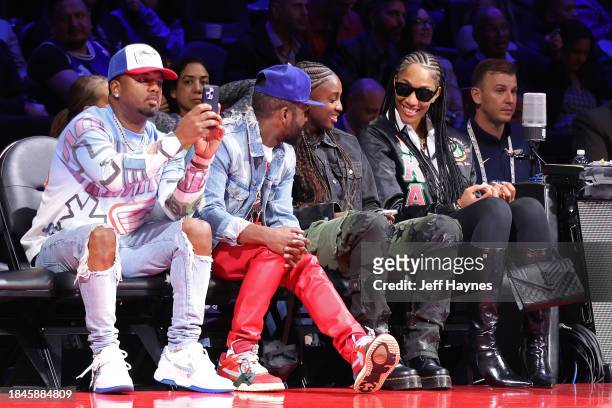 Jackie Young and A'ja Wilson of the Las Vegas Aces talk to former professional boxer Floyd Mayweather Jr. During the game between the New Orleans...
