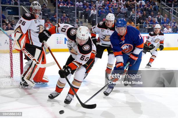 Jackson LaCombe of the Anaheim Ducks and Julien Gauthier of the New York Islanders battle for the puck during the first period at UBS Arena on...