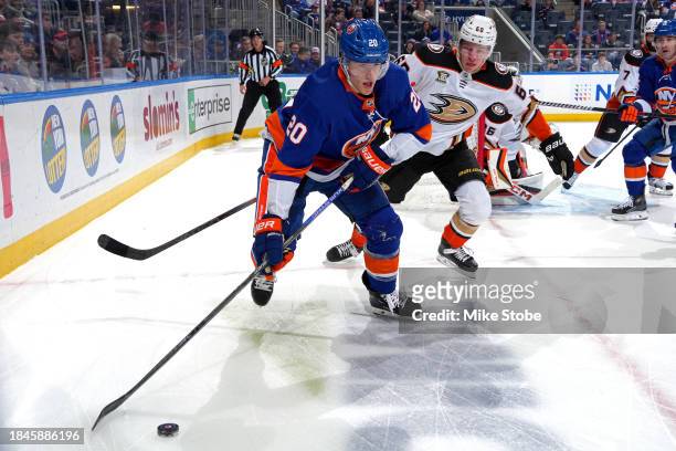 Hudson Fasching of the New York Islanders is defended by Jackson LaCombe of the Anaheim Ducks during the first period at UBS Arena on December 13,...