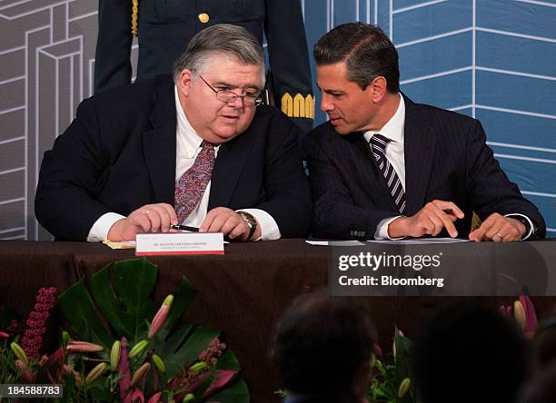 Agustin Carstens, governor of Banco de Mexico, left, speaks with Enrique Pena Nieto, Mexico's president, during the Banco de Mexico 20th Anniversary...