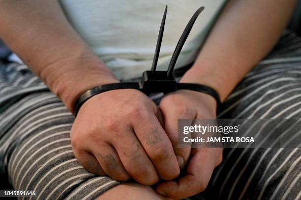 Chinese national is seen on a bus ahead of his deportation after he and others were detained in a raid on a suspected sex trafficking and online scam...