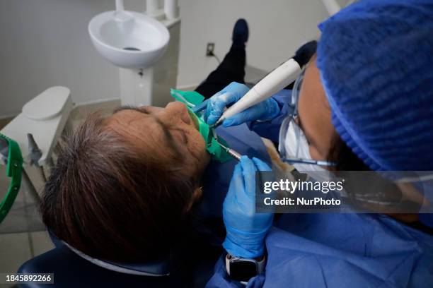 Dentist at the Centro de Salud TIII Doctor Guillermo Roman y Carrillo in the Iztapalapa district of Mexico City is attending to an older adult who is...