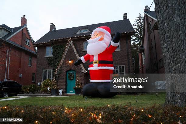 An inflatable Santa Claus decoration is seen on Inglewood Drive in Toronto, Ontario on December 13, 2023. Inglewood Drive neighbourhood put up...