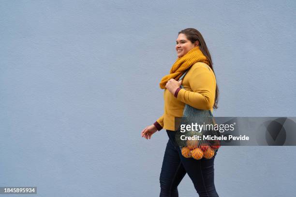 latin woman carrying sustainable bags - latin american and hispanic shopping bags stockfoto's en -beelden