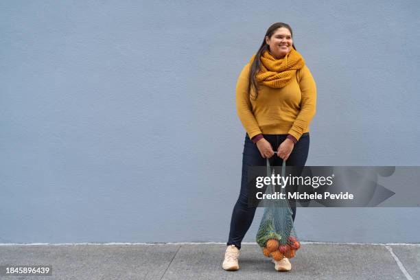 latin woman carrying sustainable bags - latin american and hispanic shopping bags stockfoto's en -beelden