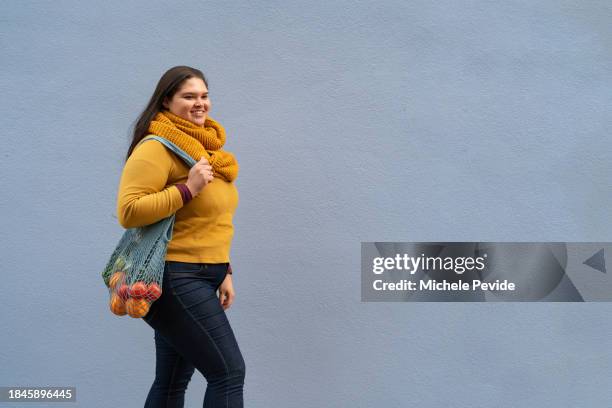 latin woman carrying sustainable bags - latin american and hispanic shopping bags stockfoto's en -beelden