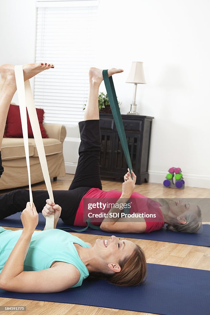 Correa de socios haciendo yoga ejercicios de estiramiento en la sala de estar