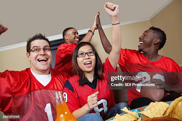 football-fans wie zu hause vor dem spiel auf dem fernseher - sporttrikot stock-fotos und bilder