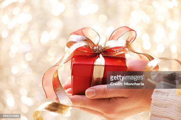 giving a christmas present - gold meets golden stock pictures, royalty-free photos & images