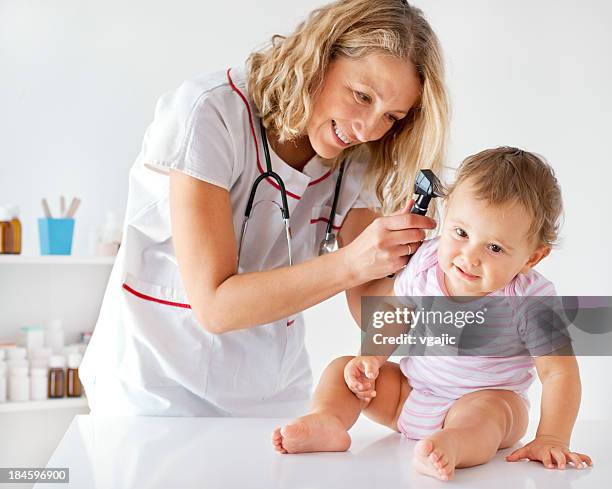 weibliche kinderarzt tun hno-untersuchung eines patienten babys – mädchen - ear exam stock-fotos und bilder