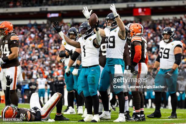 Travis Etienne Jr. #1 of the Jacksonville Jaguars and Jeremiah Ledbetter signal a touchdown during the game against the Cleveland Browns at Cleveland...