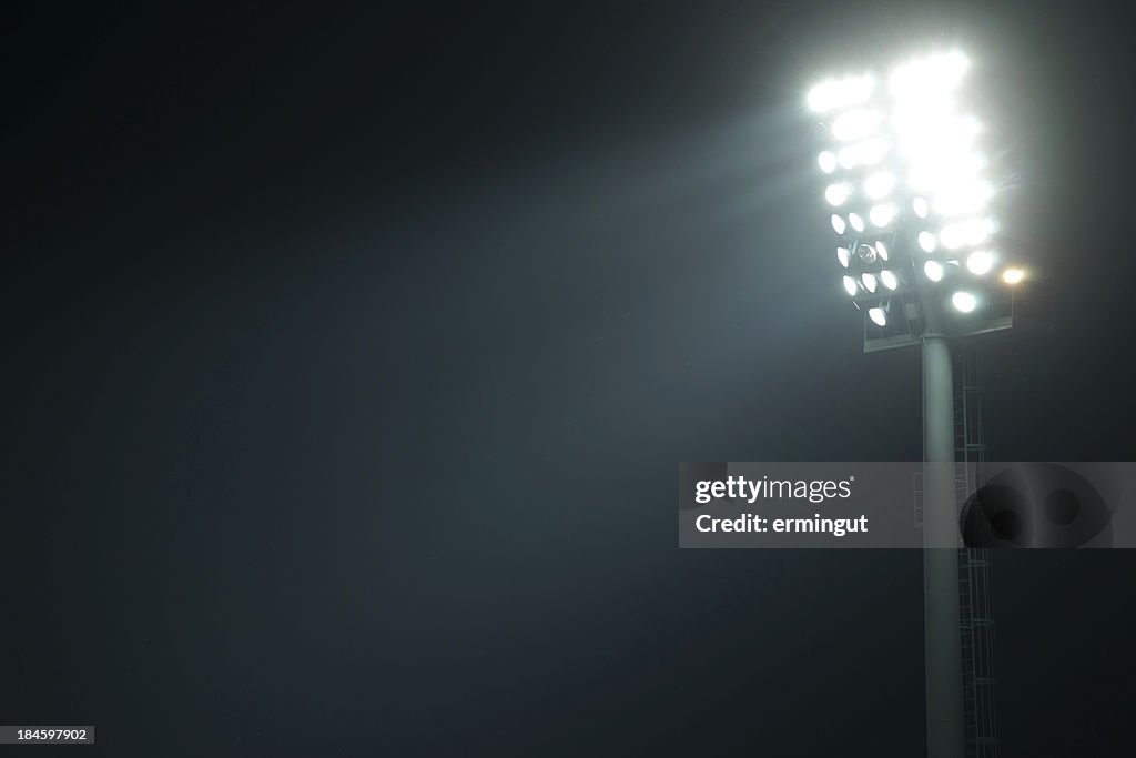 Front view of stadium lights with light beams