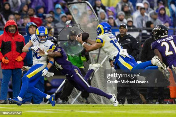 Puka Nacua of the Los Angeles Rams dives and completes a pass against Brandon Stephens of the Baltimore Ravens as Cooper Kupp of the Los Angeles Rams...
