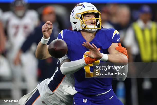 Easton Stick of the Los Angeles Chargers is sacked by P.J. Locke of the Denver Broncos during the fourth quarter at SoFi Stadium on December 10, 2023...