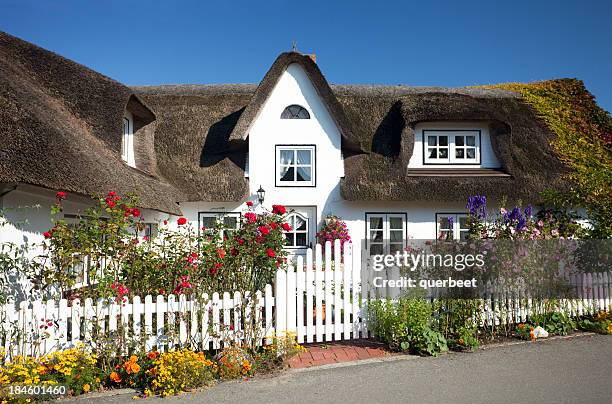 cottage mit strohdach stroh auf dem dach - einfamilienhaus stock-fotos und bilder