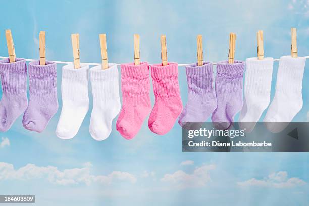 baby socken hängen auf einer wäscheleine - strümpfe stock-fotos und bilder