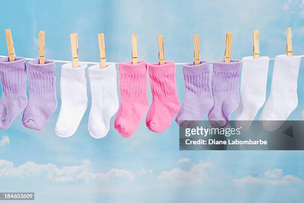 bebé calcetines colgar en una cuerda de tender la ropa - socks fotografías e imágenes de stock