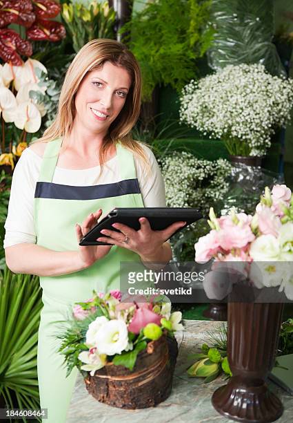 attractive florist at work using digital tablet - multi platinum selling stock pictures, royalty-free photos & images