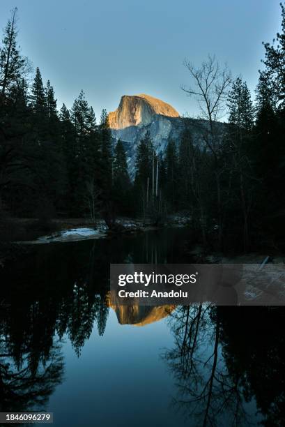 Half Dome view with reflection during sunset in Yosemite National Park of California, United States on December 13, 2023.