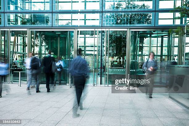 business people entering and exiting an office building, blurred motion - building entrance stock pictures, royalty-free photos & images