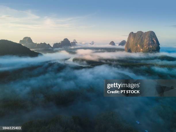 aerial view drone green mountains, forests and streams stretching out to sea, many paths with mist and sunrise at phang nga bay, phang nga, thailand. - provincia di phang nga foto e immagini stock