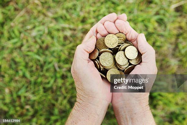 hands holding australian dollar coins over grass - cash australia stock pictures, royalty-free photos & images