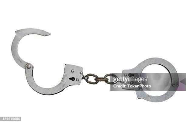 metal handcuffs with one half open on a white surface - handboeien stockfoto's en -beelden