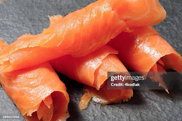 close-up of rolls of smoked salmon on a gray background - smoked stock pictures, royalty-free photos & images