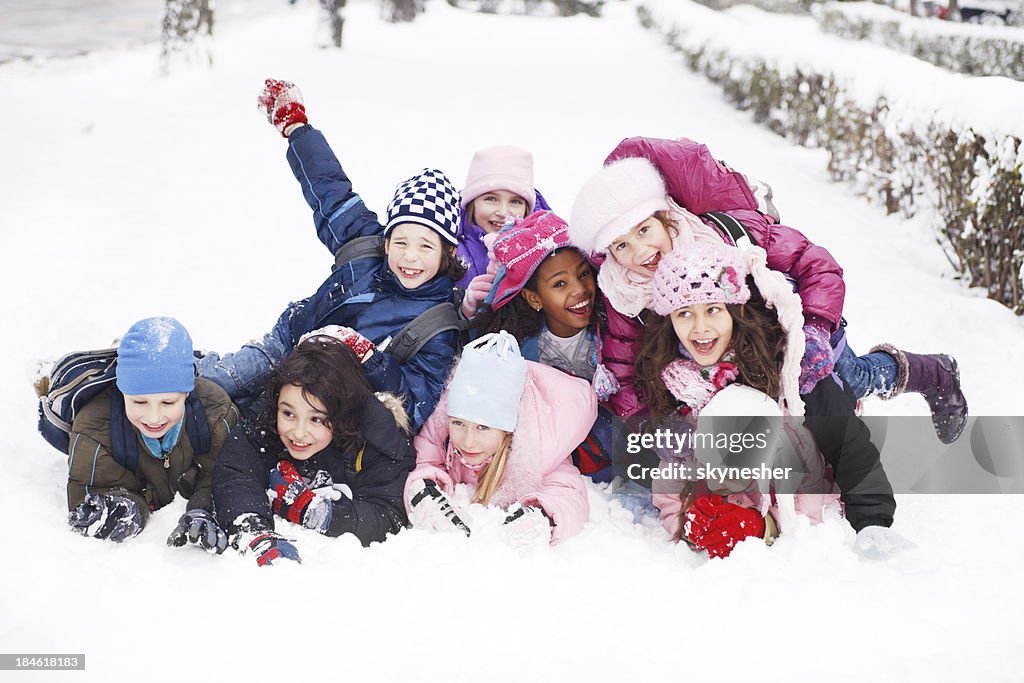 Lustiger Gruppe von Kindern im Schnee liegen.