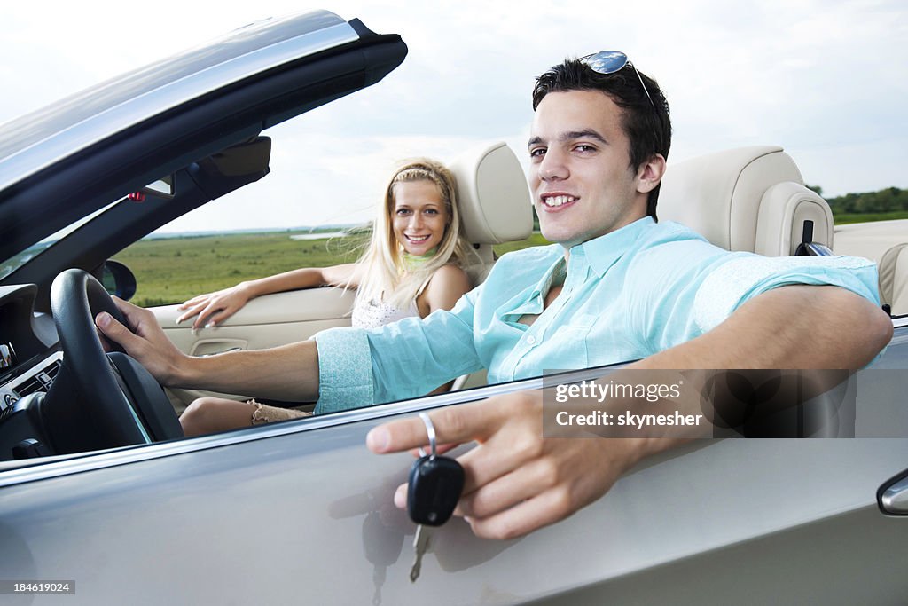 Beautiful couple sitting in their Convertible car.