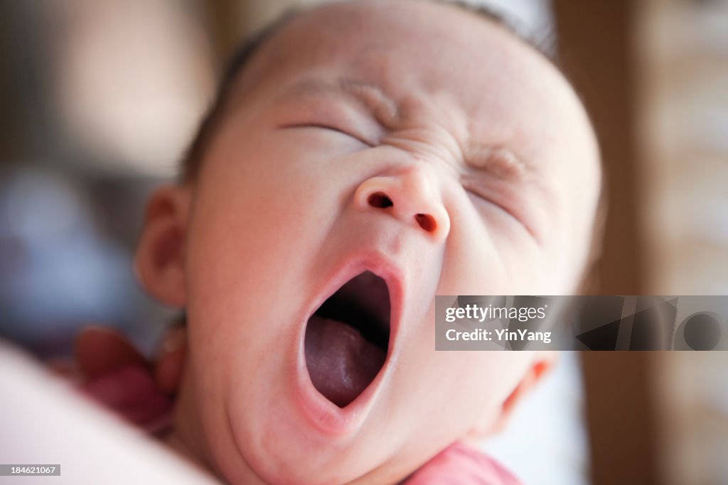 Sleepy drei Monate alte asiatische Baby Gähnen
