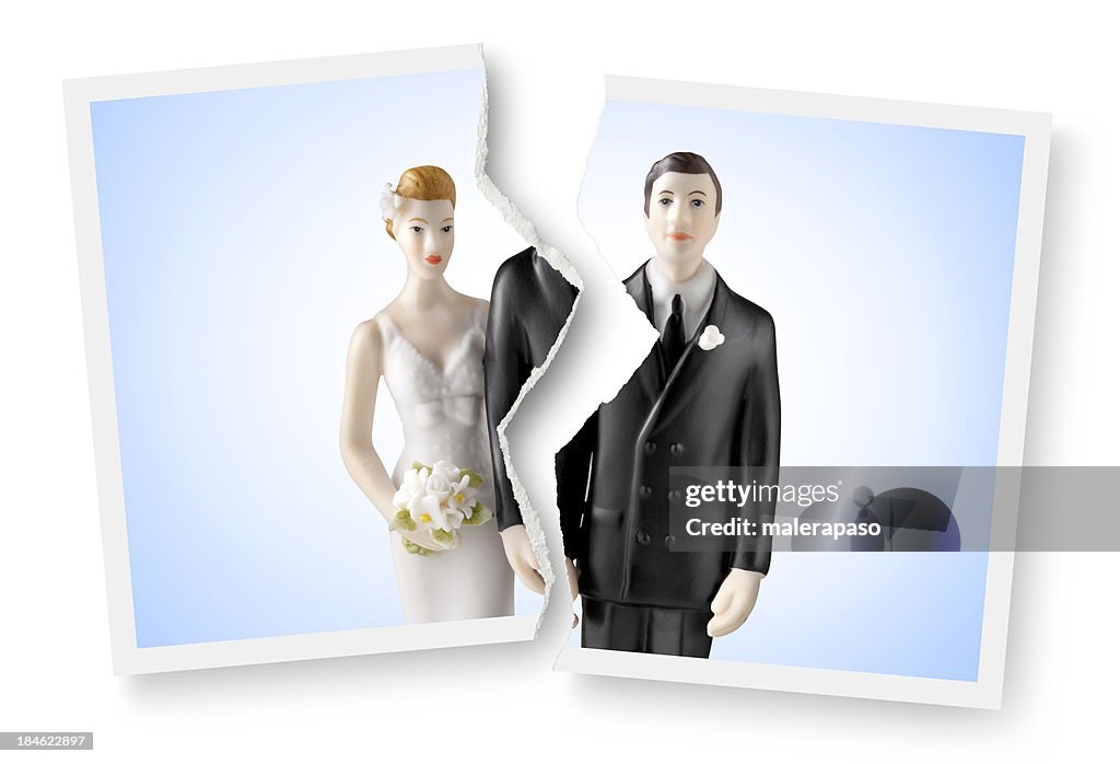 Divorce. Torn photograph of wedding cake topper.