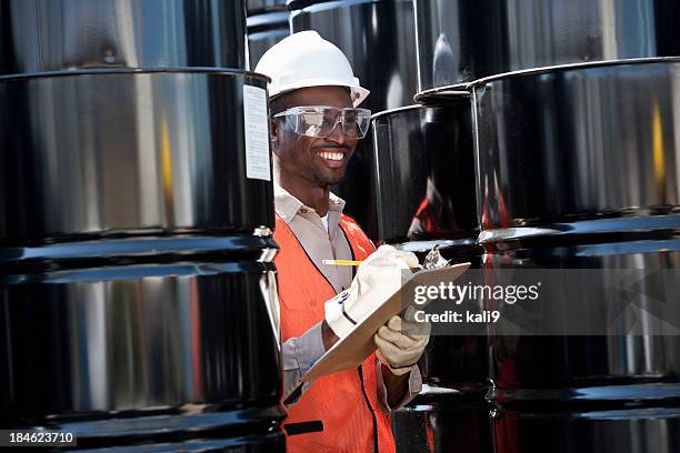 junge männliche arbeiter in industrielle anlage - stahlfass stock-fotos und bilder