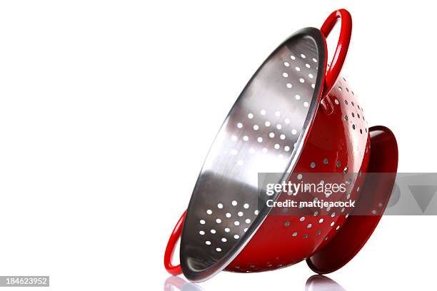 shiny, red colander on its side with white background.  - colander stock pictures, royalty-free photos & images