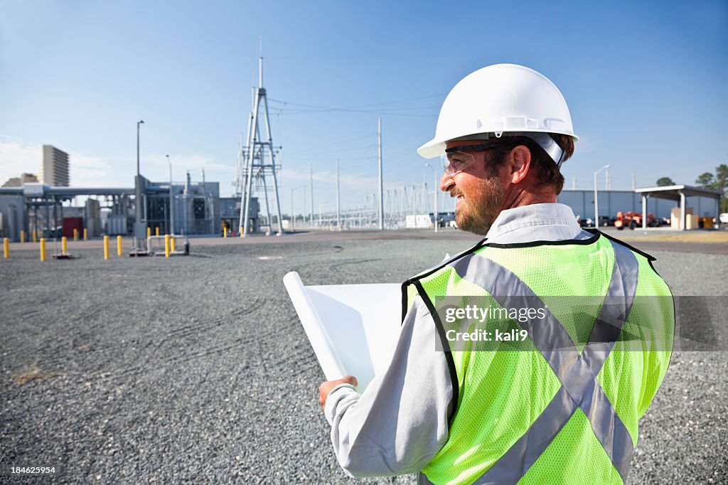 Ingenieur hält Pläne Betrachtung power station