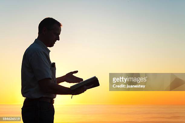 hombre leyendo un libro de conocimiento - evangelista fotografías e imágenes de stock