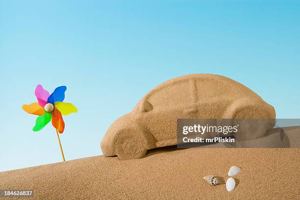 sand sculpture of car beside toy windmill - sand sculpture stockfoto's en -beelden