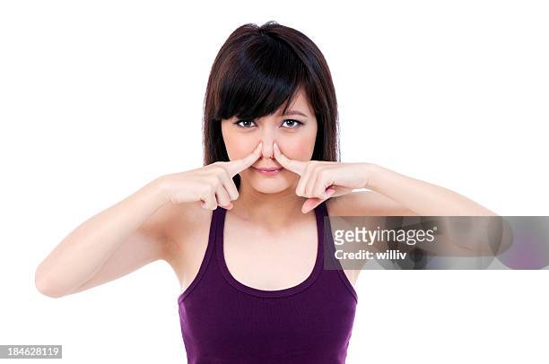 young asian woman pressing against her nose - human nose isolated stock pictures, royalty-free photos & images