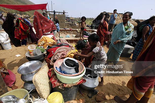 Fishermen family salvage things from their house damaged during Cyclone Phailin at the fishermen's village in New Podampetta village near Humma on...