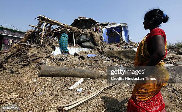 Fishermen family salvage materials from their house damaged during Cyclone Phailin at the fishermen's village in New Podampetta village near Humma on...