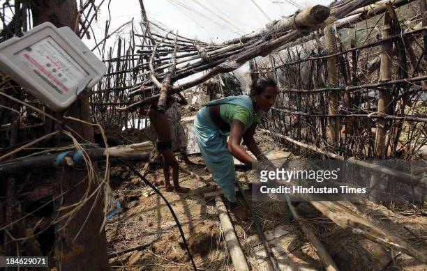 Fishermen family salvage materials from their house damaged during Cyclone Phailin at the fishermen's village in New Podampetta village near Humma on...
