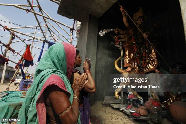 Hndu women worship Mother Durga on the occasion of Bijoy Dashmi following cyclone Phailin at the fishermen colony on October 14, 2013 in Arjapalli...