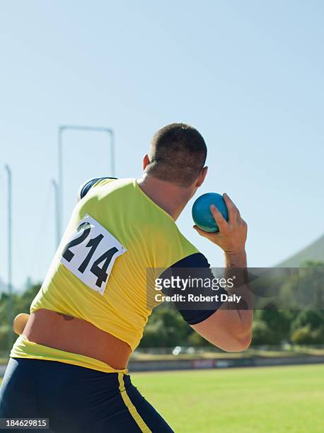 athlete shot putting in an arena - shot put stock pictures, royalty-free photos & images