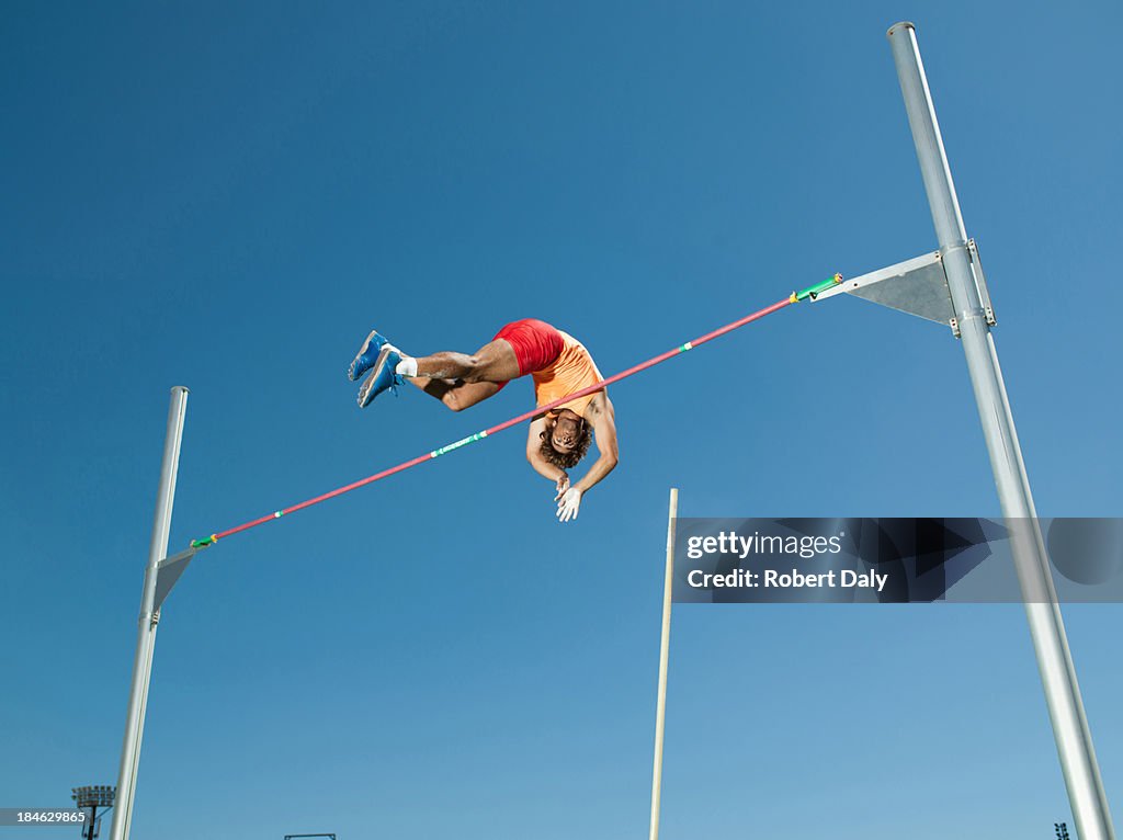 Athlete in mid air doing pole vault