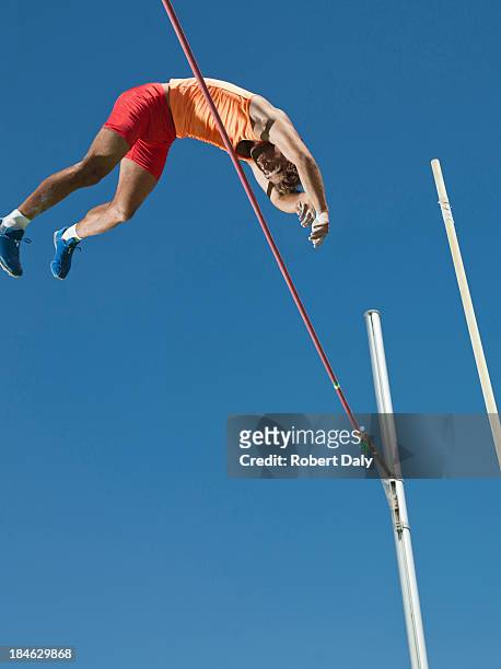 athlete in mid air doing pole vault - pole vault stock pictures, royalty-free photos & images