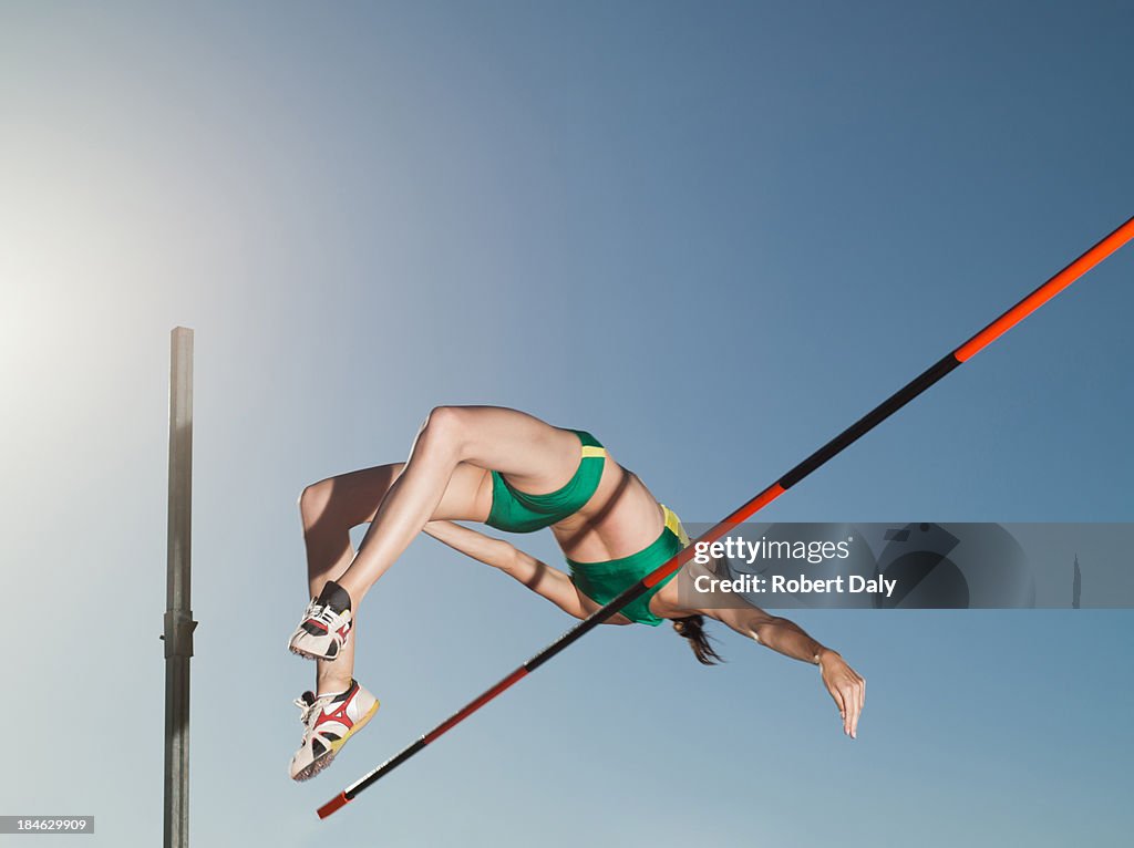 Athlete high jumping in an arena