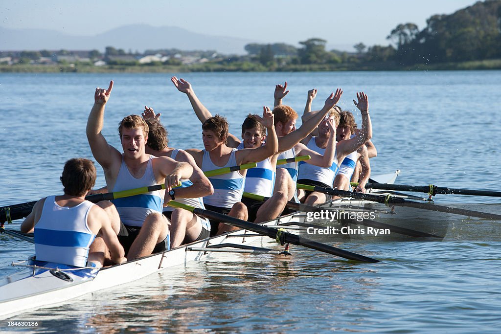 Athletes in a crew row boat cheering